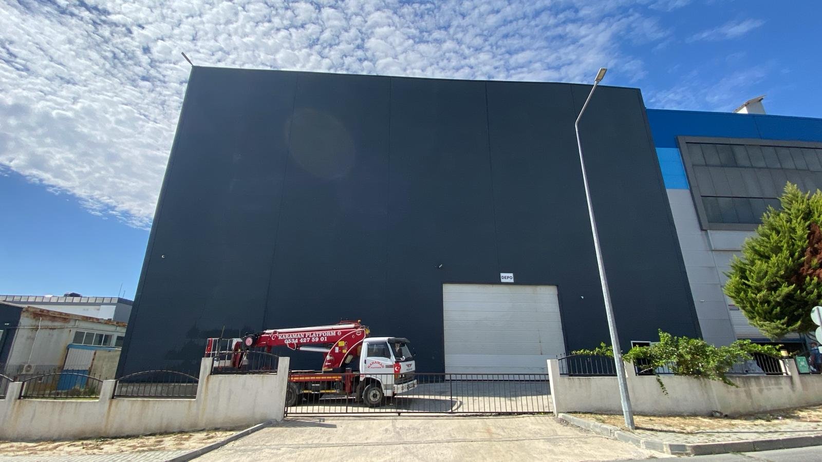 Cephe ekibi sepetli platformla fabrika cephesini yıkarken